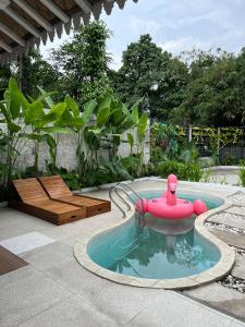 a small pool with a red toy in a garden at Sampai Villa Nayan in Yogyakarta