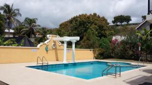 布里奇敦的住宿－10 Springcourt Barbados，一座房子旁边的游泳池,带水滑梯