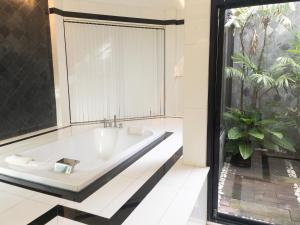 een badkuip in een kamer met een groot raam bij Paradise House in Thai Muang