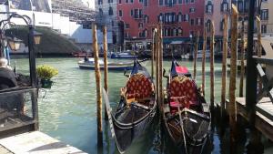 three gondolas are docked in the water in a canal at Palazzo del Sale, Rialto in Venice