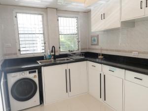 een keuken met witte kasten en een wasmachine bij Paradise House in Thai Muang +42 foto's