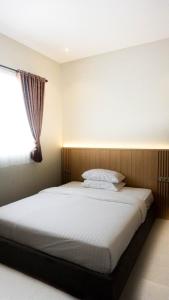 a bedroom with a large bed with a window at Wisma Lotus 2 Purwokerto in Banyumas +16 photos