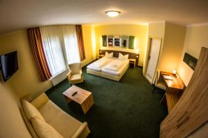 a hotel room with a bed and a couch at Gästehaus Blaue Ecke in Adenau