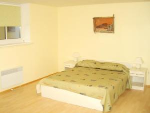 a small bedroom with a bed and two night stands at Vaivorykštė in Nida