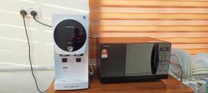 a microwave on a table next to at Bumiemas Homestay - 2 BEDROOM in Kangar +1 photo