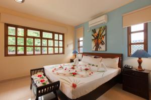a bedroom with a large bed with flowers on it at Le Relax Self Catering Apartment in La Digue