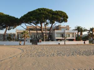 ein Haus am Strand mit Bäumen davor in der Unterkunft Apartamentos Haus Am Meer in Cambrils