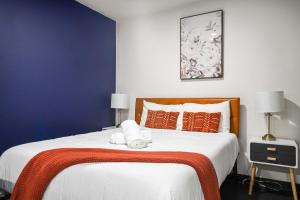 a bedroom with a large white bed with orange pillows at CozySuites Stunning 1BR in Downtown Pitts #1 in Pittsburgh