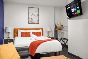 a bedroom with a bed and a tv on a wall at CozySuites Stunning 1BR in Downtown Pitts #1 in Pittsburgh