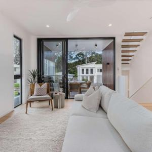 a living room with a white couch and a table at Lakehouse No 2- Lakefront Luxury Escape Villa - Pet Friendly in Cabarita Beach +42 photos