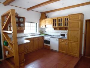 a kitchen with wooden cabinets and white appliances at Apartamento Bela Vista in Pereira