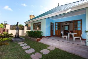 a small house with a table and chairs in a yard at Le Relax Self Catering Apartment in La Digue