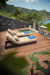 a deck with a swimming pool and a chair and a pool at Vigia da Areia in São Lourenço