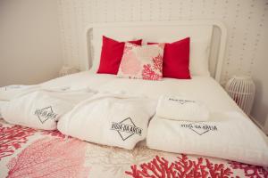 a bed with white blankets and pillows on it at Vigia da Areia in São Lourenço +30 photos