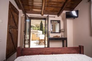 a bedroom with a bed and a desk and a mirror at Villa Galanthus in Lístaros