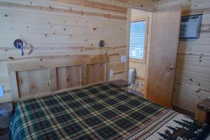 1 dormitorio con 1 cama en una cabaña de madera en Leavenworth Camping Resort Cottage 7, en Leavenworth