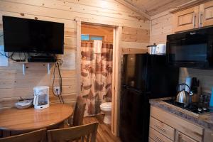 a small kitchen with a table and a refrigerator at Leavenworth Camping Resort Cottage 7 in Leavenworth