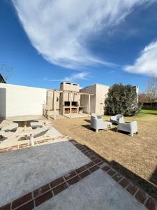 un patio avec des chaises et une table et un bâtiment dans l'établissement Casa de pueblo, à Cañada Rosquín