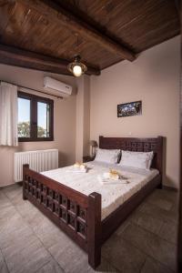 a bedroom with a large wooden bed in a room at Villa Galanthus in Lístaros