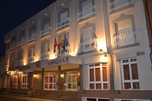 um edifício com bandeiras na lateral em Hotel Ramomar em Tomelloso