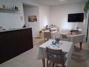 a restaurant with tables and chairs and a flat screen tv at Prestige Affittacamere Paestum in Stazione di Paestum