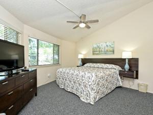 a bedroom with a bed and a ceiling fan at Treehouse Bungalow - Community Poolhot Tub #12 in Lakeway +8 photos
