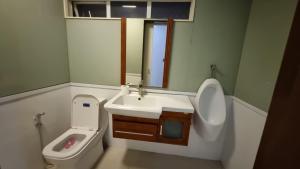 a bathroom with a sink and a toilet and a mirror at Baguio Brentwood Villas in Baguio +13 photos