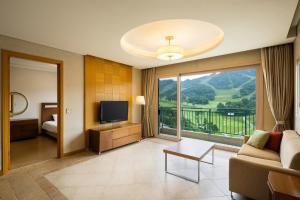a living room with a couch and a television at OakValley Resort Hills Village in Wonju