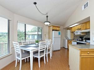 eine Küche und ein Esszimmer mit Tisch und Stühlen in der Unterkunft Lakefront Bungalow With Community Poolhot Tub #8 in Lakeway