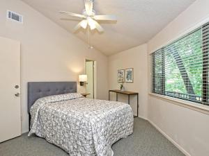 a bedroom with a bed and a ceiling fan at Lakefront Bungalow - Community Poolhot Tub #6 in Lakeway +12 photos