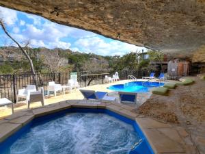 a pool in a backyard with chairs and a table at Lakefront Bungalow - Community Poolhot Tub #6 in Lakeway