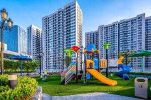 a playground with a slide in a park with tall buildings at Moon Homestay 1717 in Gia Lâm Pho