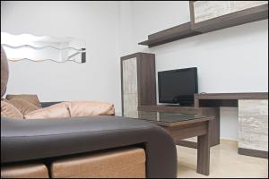 sala de estar con sofá y mesa con TV en Apartamento Loyola, en Conil de la Frontera