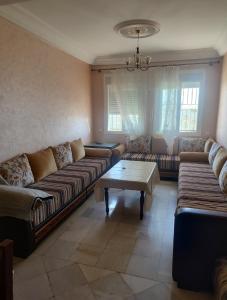 a living room with couches and a coffee table at Dyar alboughaz in Hajreien