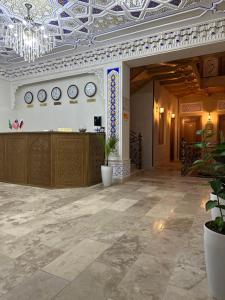 Habitación grande con reloj en la pared y vestíbulo en Zarhal Boutique, en Bukhara