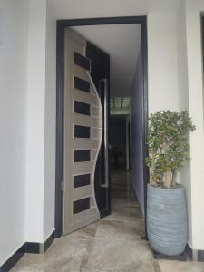 a hallway with a door with a plant in a barrel at Minisuit, Loja in Loja