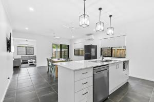 a white kitchen with a sink and a counter at Charlotte's Place in Caboolture