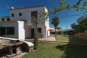 une maison blanche avec un banc dans la cour dans l'établissement Akivillas Albufeira Vale, à Albufeira