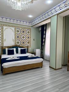 Un dormitorio con una cama y una lámpara de araña. en Zarhal Boutique, en Bukhara