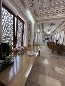 Habitación grande con mesa de madera en un edificio en Zarhal Boutique, en Bukhara