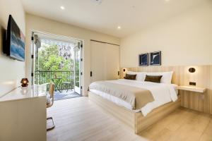 a bedroom with a large bed and a balcony at Casa De La Vina - Boutique Apartments in Downtown Santa Barbara in Santa Barbara