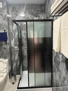 a bathroom with a shower with a glass door at Urban Luxe in Almaty