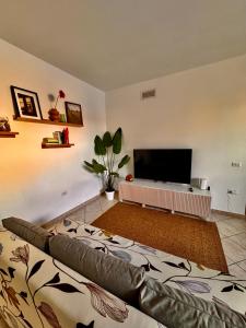 een woonkamer met een bank en een flatscreen-tv bij Casa Agata - La Casa in Sardegna in Tortolì