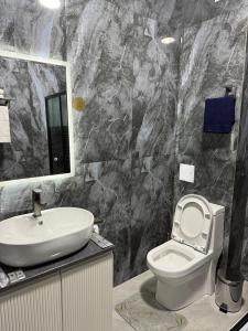 a bathroom with a sink and a toilet and a mirror at Urban Luxe in Almaty