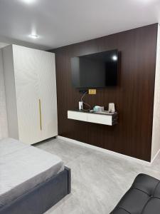 a bedroom with a bed and a tv on a wall at Urban Luxe in Almaty +15 photos