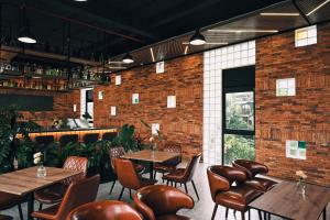 a restaurant with tables and chairs and a brick wall at Ấm Boutique Hotel in Ấp Ða Lợi
