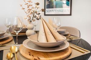 a table with a plate of napkins on a table with wine glasses at CITY-LOFT 1!Gratis parken, Free parking! in Schaffhausen +5 photos