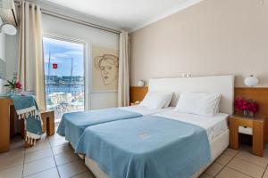 a hotel room with a bed with a blue blanket at Hotel Akti in Skiathos