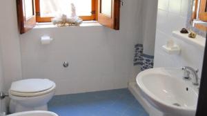 ein weißes Badezimmer mit Toilette und Waschbecken in der Unterkunft Le Rose in Marina di Camerota