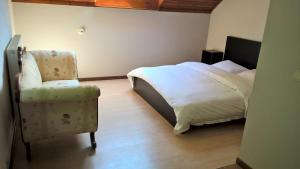 a bedroom with a bed and a chair at Villa Sous-Bois Marie in Spa
